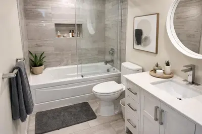 a bathroom with a tub and a toilet and a sink at Chic 2BR Tinseltown Condo - Walk to Stadiums in Vancouver