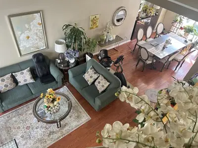 a living room with a couch and a dining room at Spacious 3-Bedroom House, Queen Beds, Flexible Guests in Coquitlam