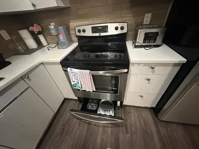a small kitchen with a stove and a microwave at Stylish Open Cozy & Contemporary Living Space in Prince George
