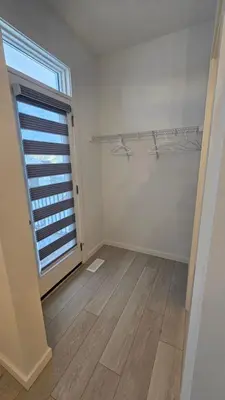 an empty room with a large window and a wooden floor at 3 Bedroom Modern Luxury House - Family Friendly, 3 Queen Beds, Free Wi-Fi, and Free Parking in Calgary