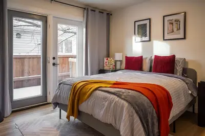 a bedroom with a bed and a sliding glass door at Modern 3Bed Home with Fireplace, Game Room, and Stylish Comfort Just 12 Minutes from Downtown Calgary in Calgary