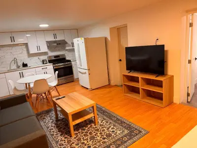 a living room with a refrigerator and a table at Amalak Homes' Private 2BR Guest Suite North Delta in Delta
