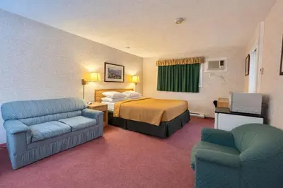 a hotel room with a bed and two chairs at Rychter Hotel Hope in Hope