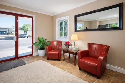 a waiting room with two chairs and a table and a mirror at Rychter Hotel Hope in Hope