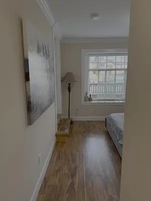 an empty bedroom with a bed and a window at Cozy 2 Bdrm suite in the Heart of Renfrew Heights in Vancouver