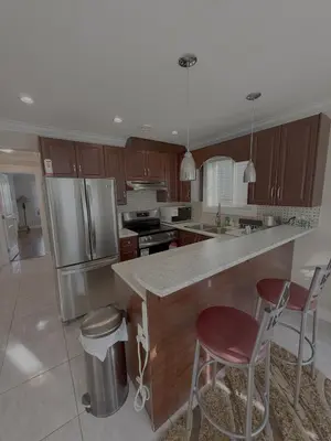 a kitchen with a counter and two bar stools at Cozy 2 Bdrm suite in the Heart of Renfrew Heights in Vancouver