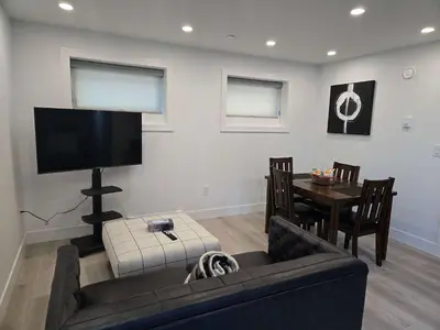 a living room with a couch and a table with a television at The Rupert Split Flexible Family Living in Vancouver