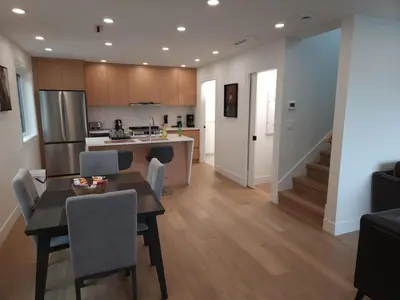 a kitchen and living room with a table and chairs at The Rupert Split Flexible Family Living in Vancouver
