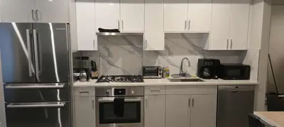 a kitchen with white cabinets and stainless steel appliances at UBC Area Gem Spacious 2-Bedroom Townhouse with Full Kitchen in Vancouver