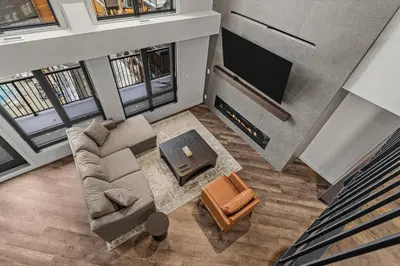 an overhead view of a living room with a couch and a tv at Penthouse Loft| 2BD| Mountain Views| Pool + HotTub in Canmore