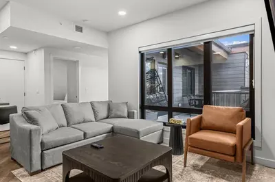 a living room with a couch and a table at Premier Suite | Mountain Views | Sleeps 10 in Canmore