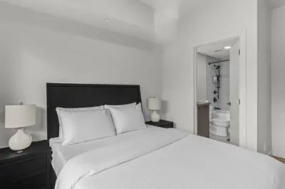 a bedroom with a large white bed with two lamps at Premier Suite | Mountain Views | Sleeps 10 in Canmore