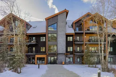 an exterior view of an apartment building in the snow at Premier Suite | Mountain Views | Sleeps 10 in Canmore