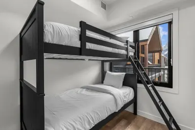 a bedroom with two bunk beds and a window at Premier Suite & Penthouse Loft - Sleeps 16 in Canmore