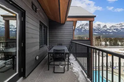 a balcony of a house with a table and chairs at Premier Suite & Penthouse Loft - Sleeps 16 in Canmore