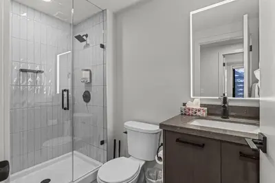 a bathroom with a shower and a toilet and a sink at Premier Suite & Penthouse Loft - Sleeps 16 in Canmore