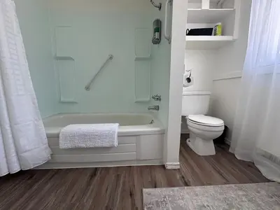 a white bathroom with a tub and a toilet at Texada Hunter Hiker friendly suite in Vananda