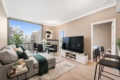 a living room with a couch and a television at Bright and Comfortable 2BR Downtown Apartment for Families and Groups in Vancouver
