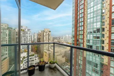 a balcony with potted plants and buildings at Bright and Comfortable 2BR Downtown Apartment for Families and Groups in Vancouver