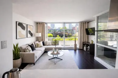 a living room with a couch and a table at Elegant 2-Bedroom Condo in Vibrant Yaletown District in Vancouver