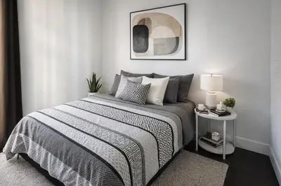 a bedroom with a bed with a black and white comforter at Elegant 2-Bedroom Condo in Vibrant Yaletown District in Vancouver