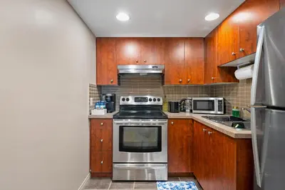 a kitchen with wooden cabinets and a stove top oven at Panorama Hills Cozy Guest Suite in Calgary