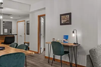 a living room with a table and chairs at Tranquil Condo In The Trees Spacious 2Bd Hot Tub & Pool in Canmore