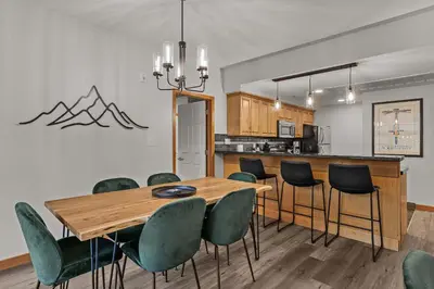 a kitchen and dining room with a table and chairs at Tranquil Condo In The Trees Spacious 2Bd Hot Tub & Pool in Canmore