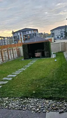 a backyard with a roof on the grass at 2 Bedroom Smart Secondary Suite with Gazebo view in Calgary