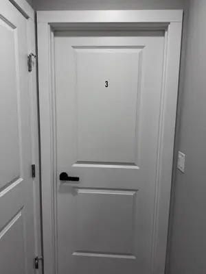 a white door with a black door knob at NorthEdge Master Suite, Leduc in Leduc