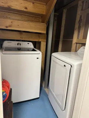 a washer and dryer sitting in a room with at Cozy 2 Bedroom Basement Apartment in Calgary