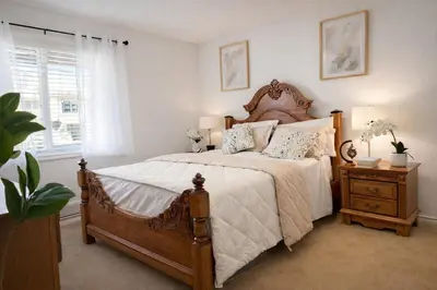 a bedroom with a large bed with a wooden headboard at Private Suite in Airdrie Near Calgary Free Parking in Airdrie
