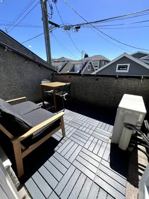 a patio with a bench and a table on a roof at A Cozy Nest, Private Tiny Home in Vancouver