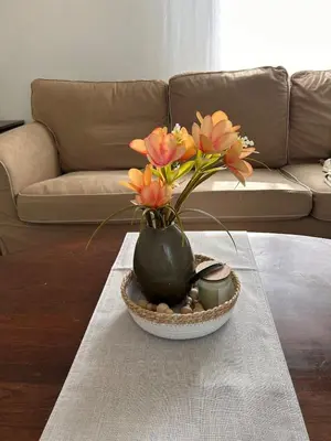 a vase filled with flowers sitting on a table at Cozy Country Cabin in Lacombe