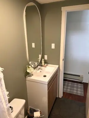 a bathroom with a sink and a mirror at Cozy Country Cabin in Lacombe