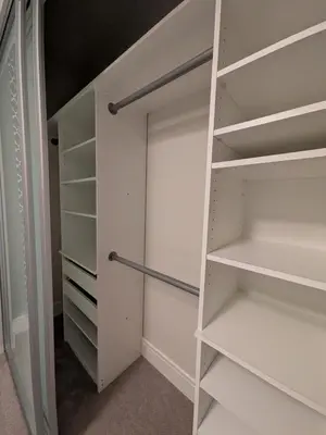a walk in closet with white shelves at Designer 2-Bedroom Garden-Level Walk-Out Suite in Surrey