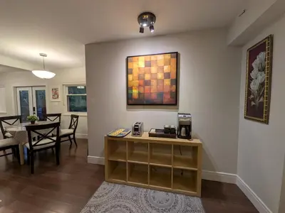 a living room with a table and a counter with a coffee maker at Designer 2-Bedroom Garden-Level Walk-Out Suite in Surrey