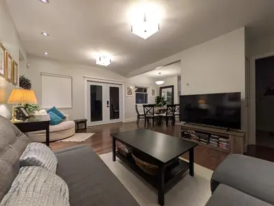 a living room with a couch and a tv at Designer 2-Bedroom Garden-Level Walk-Out Suite in Surrey