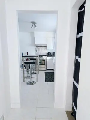 a kitchen with white walls and a white tile floor at Bohemian Theme Private Room near Metrotown Mall with private parking in Burnaby