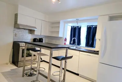 a kitchen with a table and some chairs in it at Bohemian Theme Private Room near Metrotown Mall with private parking in Burnaby