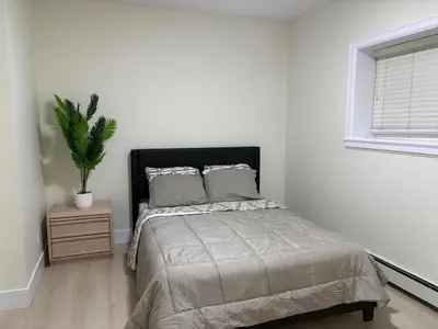 a bedroom with a bed and a potted plant at Cozy Home in Surrey