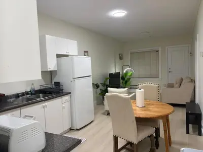 a kitchen and dining room with a table and white appliances at Cozy Home in Surrey