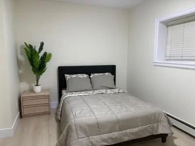 a bedroom with a bed and a potted plant at Cozy Home in Surrey