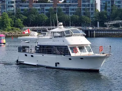 a white boat in the water with buildings in the background at Shangri-la Joy in Vancouver