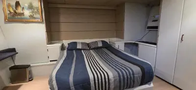 a small bedroom with a bed with a striped blanket at Shangri-la Joy in Vancouver