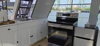 a kitchen with a stove and a sink and a window at Shangri-la Joy in Vancouver