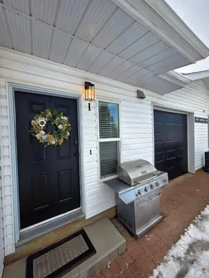 a front door of a house with a grill at Small Town Pearl l Charming & Cozy 2 Level Suite Near Red Deer l Yard & BBQ in Penhold