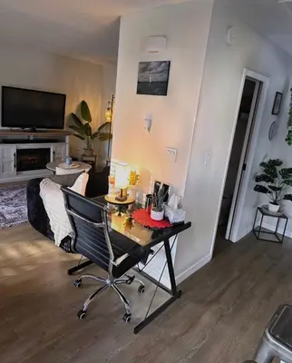 a living room with a desk and a chair at Small Town Pearl l Charming & Cozy 2 Level Suite Near Red Deer l Yard & BBQ in Penhold