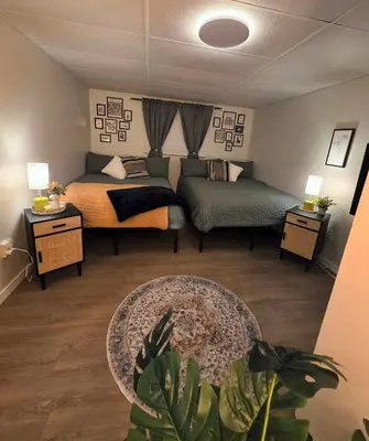 a living room with a bed and a couch at Small Town Pearl l Charming & Cozy 2 Level Suite Near Red Deer l Yard & BBQ in Penhold