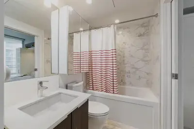 a bathroom with a sink and a toilet and a tub at 25 Days Minimum - Luxury and Modern Downtown Apartment - Do not send request for less than 21 days in Vancouver